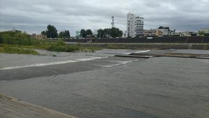 川に向かって座れる席から見た豊平川。前日の雨の影響で水量が多く見え、対岸の河川敷と建物が見える