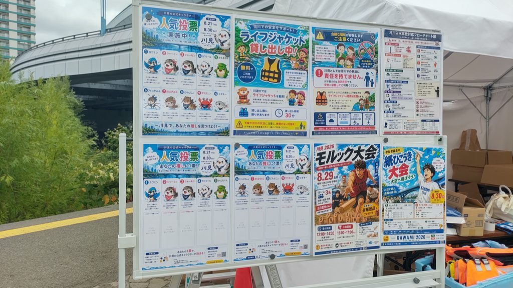 川見2026会場内の掲示板。ライフジャケット貸し出し中の案内や、人気投票、モルック大会、紙飛行機大会のポスターが掲示されている