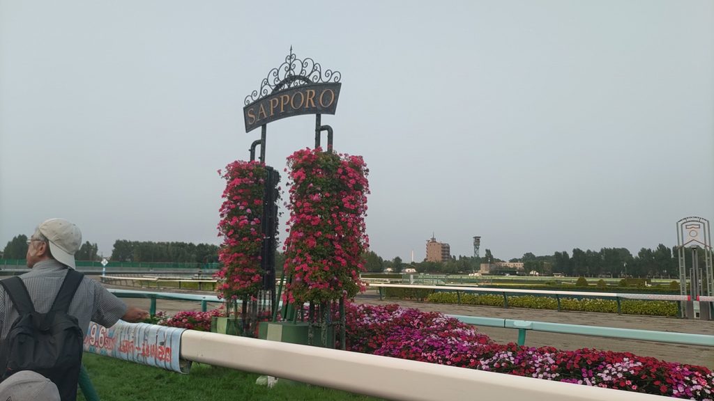 花で飾られたSAPPOROの表示と札幌競馬場のゴール付近
