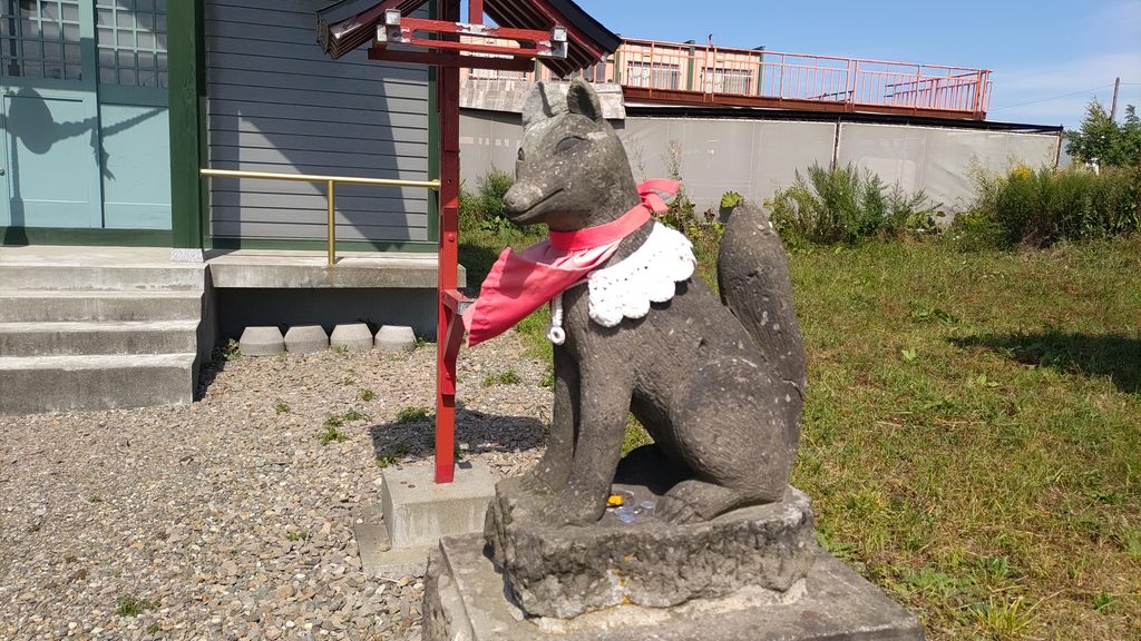 豊畑神社の社殿前にある赤い布を巻いた狛狐