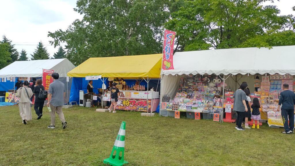 芝生の上に屋台が並ぶ燃えれ！わが街2026の会場2