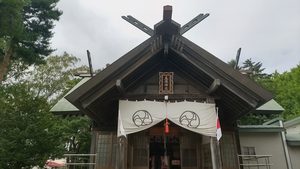 白い幕が張られ、両側に国旗が掲げられた丘珠神社の社殿