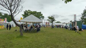 芝生の会場に屋台とテント付きの休憩席が並ぶ様子