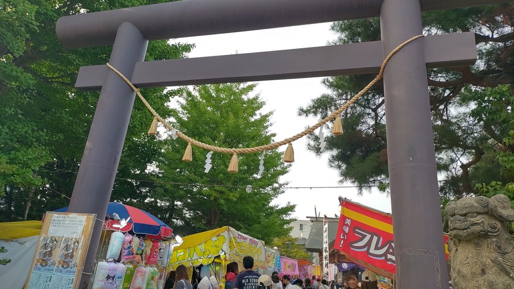 例大祭の飾り付けがされた札幌村神社の鳥居と露店