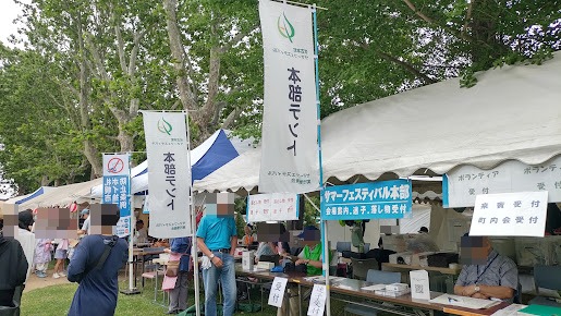 伏古本町サマーフェスティバル本部のテントと、会場案内・迷子・落とし物受付の看板