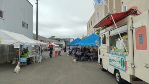 キッチンカーとテントが両側に並び、奥に休憩席が見える会場通路