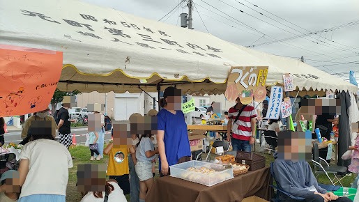 テント内のパン販売ブースと周囲に集まる子どもや来場者