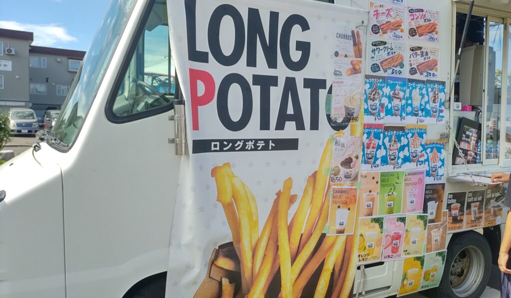 ロングポテトやソフトクリーム、ドリンクのメニューが並ぶキッチンカー