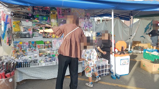 北栄盆踊り大会の子ども向け露店で、玩具や景品を見ている親子の様子