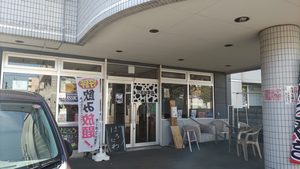 札幌市東区北28条東15丁目にあるたこ焼き店「ぽろにわ」の外観。建物1階の入口にのぼりや看板が設置されている。