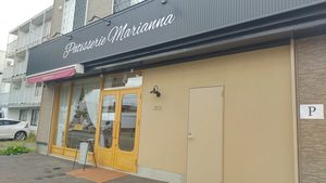 札幌市東区の菓子工房マリアンナの外観。黒い看板に白文字で店名が書かれ、木製の両開きドアがある